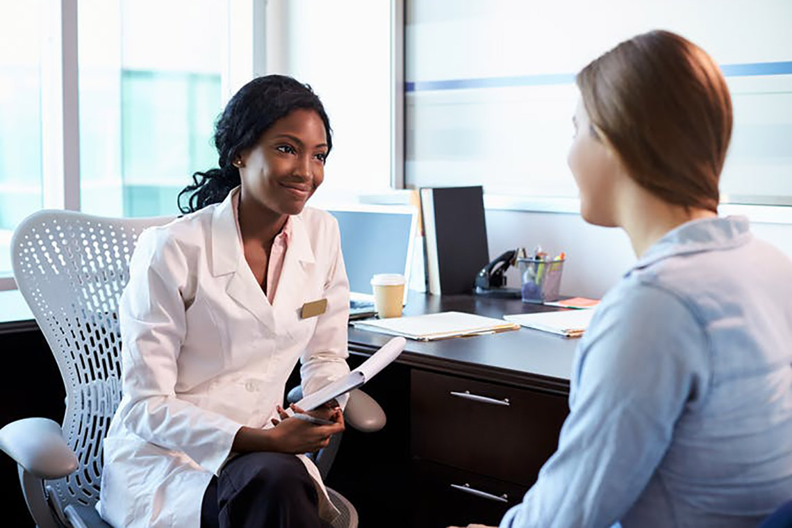 Foreign doctor reviewing a patient's medical dashboard on a tablet in a hospital room